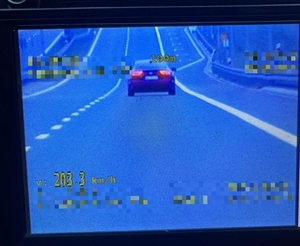 Zdjęcie z policyjnego wideorejstratora. Widoczny samochód i pomiar urządzenia - napis 203.3 km/h