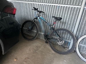 przy blaszanej ścianie garażu stoi rower górski