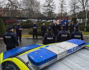 umundurowani policjanci na parkingu przed komendą policji w Przemyślu i zaparkowane radiowozy, podczas przekazania  nowych radiowozów.