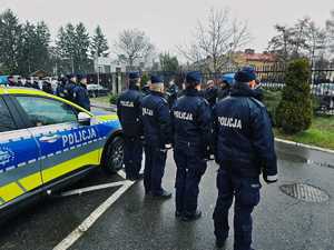 umundurowani policjanci na parkingu przed komendą policji w Przemyślu i zaparkowane radiowozy, podczas przekazania  nowych radiowozów.