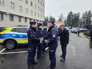 umundurowani policjanci na parkingu przed komendą policji w Przemyślu i zaparkowane radiowozy, podczas przekazania  nowych radiowozów.