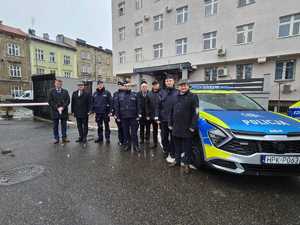 umundurowani policjanci na parkingu przed komendą policji w Przemyślu i zaparkowane radiowozy, podczas przekazania  nowych radiowozów.