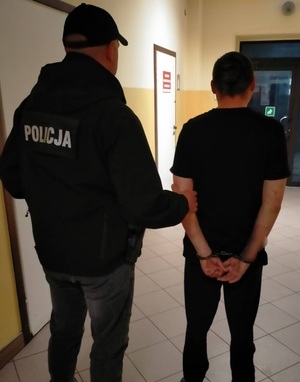 policjant prowadzący zatrzymanego mężczyznę