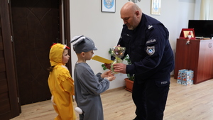 Dwoje przedszkolaków , dziewczynka przebrana za kurczaczka i chłopiec za zajączka składają życzenia policjantom z przemyskiej komendy.