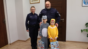 Dwoje przedszkolaków , dziewczynka przebrana za kurczaczka i chłopiec za zajączka składają życzenia policjantom z przemyskiej komendy.