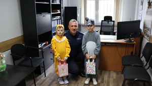 Dwoje przedszkolaków , dziewczynka przebrana za kurczaczka i chłopiec za zajączka składają życzenia policjantom z przemyskiej komendy.