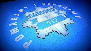 Policyjna gwiazda na niebieskim tle, z napisem Pomagamy i chronimy oraz numerem alarmowym 112