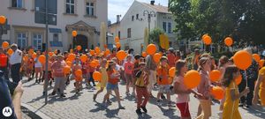 Przemarsz dzieci z Przeworskich szkół ulicami miasta z pomarańczowymi balonikami