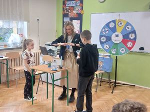 Przedstawicielka Wód Polskich wykonuje doświadczenia z dziećmi używając do nich wody