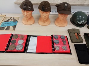 Funkcjonariusz zaprezentował kolekcję monet oraz czapek wojskowych i hełmów z okresu stanu wojennego