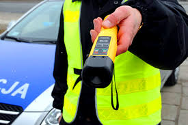 Policjant trzyma w ręce alco -sensor