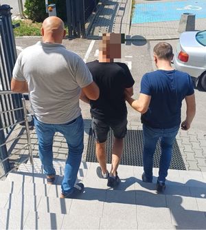 Policjanci doprowadzający zatrzymanego