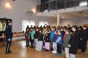 Policjant podczas pokazu mundurów wojskowych i profilaktyki z młodzież