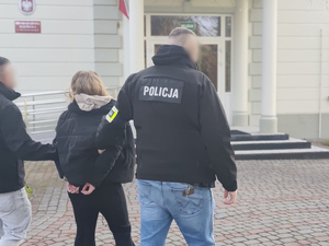 Policjanci prowadzą osobę zatrzymaną