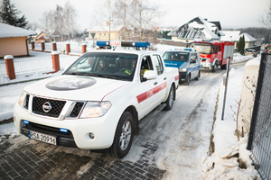 Radiowóz i samochody strażackie jadące do DPS w Sanoku