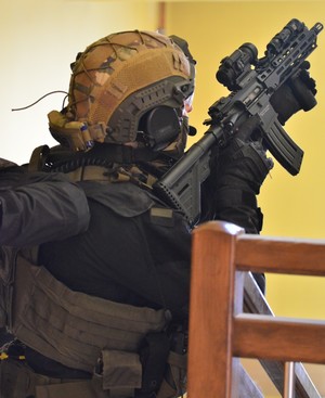 Na zdjęciu widać policjantów z grupy kontrterrorystycznej z Rzeszowa podczas ćwiczeń w Sanoku. Policjanci są wyposażeni w sprzęt specjalistyczny. Widać również nieumundurowanych policjantów sanockiego wydziału kryminalnego. Przemieszczają się z pistoletami w rękach udzielając sobie wzajemnej asysty.