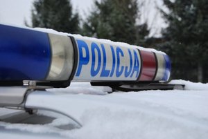 Belka z napisem POLICJA na dachu radiowozu.