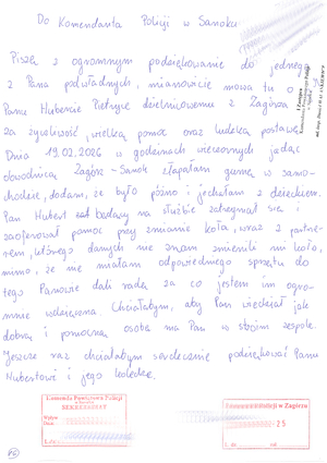 Policjant pomagający w wymianie koła w samochodzie. Właściciel pojazdy przesłał podziękowanie.