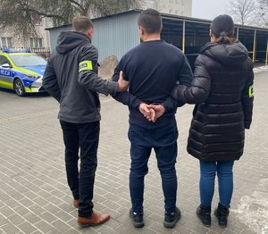 Policjanci podczas doprowadzenia zatrzymanego