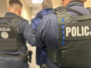 POLICJANCI DOPROWADZAJĄCY ZATRZYMANEGO DO SĄDU