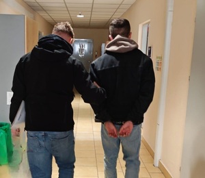 Policjanci prowadzący zatrzymanych