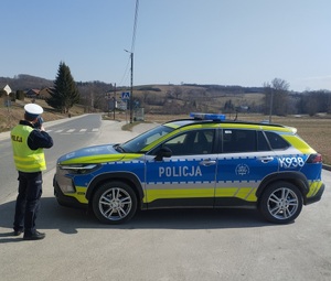 Funkcjonariusz Wydziału Ruchu Drogowego trzymający urządzenie do pomiaru prędkości pojazdu